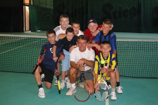 tolles Abschlussfoto mit Tennistrainer Gruppenbild Kinder und Lehrer am Tennisplatz