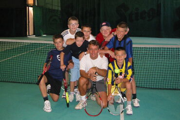 tolles Abschlussfoto mit Tennistrainer Gruppenbild Kinder und Lehrer am Tennisplatz